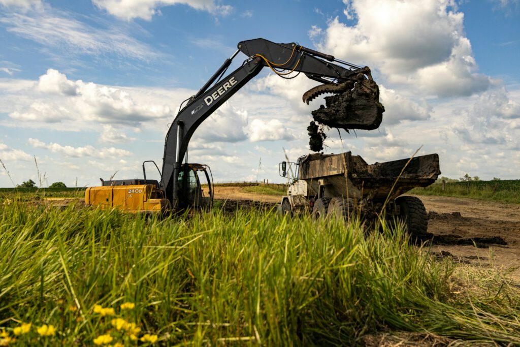 Excavator dumping dirt into a dump truck